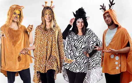 Vier Personen in Tierkostümen: ein Löwe, eine Giraffe, ein Zebra und ein Reh, die nebeneinander vor einem schlichten weißen Hintergrund stehen.