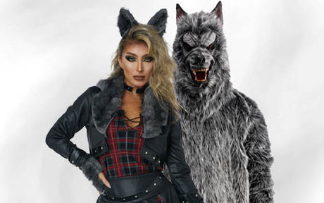Zwei Personen in Wolfskostümen posieren; die eine trägt eine Kunstfelljacke, ein kariertes Kleid und Wolfsohren, während die andere einen Ganzkörperanzug in Form eines knurrenden Wolfs trägt.
