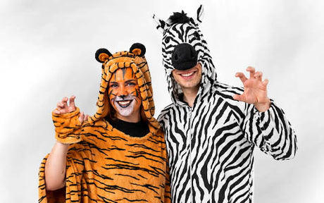 Zwei Personen in Tierkostümen: Die eine ist als Tiger verkleidet, die andere als Zebra; beide lächeln und machen spielerische Kratzbewegungen in Richtung Kamera.
