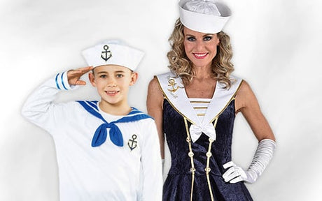 Ein Junge und eine Frau, die weiße Matrosenmützen und Kostüme im Marine-Stil tragen, posieren vor einem schlichten weißen Hintergrund.