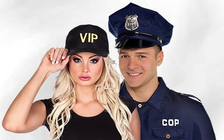 Eine Frau mit einer schwarzen VIP-Kappe steht neben einem lächelnden Mann, der ein blaues Polizistenkostüm trägt.