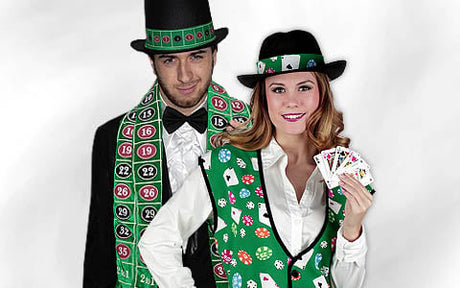 Ein Mann und eine Frau tragen Kostüme im Casino-Stil; der Mann hat einen Roulette-Schal und einen Zylinder auf, während die Frau eine Weste und einen Hut trägt, die mit Spielkarten verziert sind, und Spielkarten in der Hand hält.