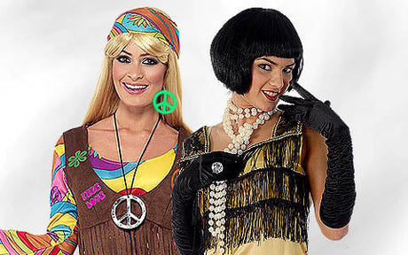 Zwei Frauen in Kostümen; die eine trägt ein Hippie-Outfit mit einem Peace-Zeichen, die andere ein Flapper-Kleid mit Perlen und Handschuhen.