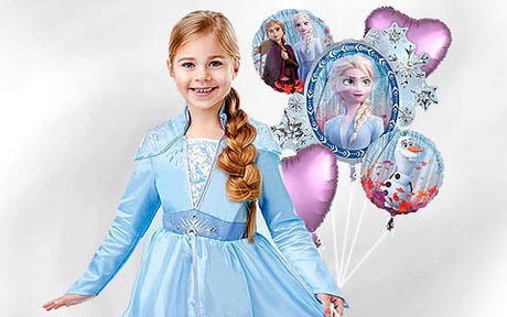 Ein kleines Mädchen in einem blauen Prinzessinnenkleid steht vor mehreren Luftballons mit Motiven aus „Die Eiskönigin“, auf denen Elsa, Anna und Olaf zu sehen sind.