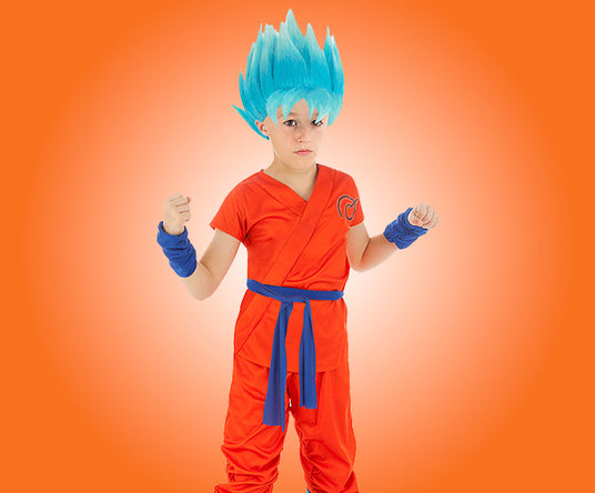 Ein Kind in einem orangefarbenen Kampfsportanzug und einer blauen, stacheligen Perücke, das mit erhobenen Fäusten vor einem orangefarbenen Hintergrund steht.