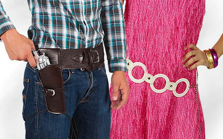 Neben einer Person in einem rosa, strukturierten Kleid mit weißem Gürtel und Armreifen steht eine Person in einem karierten Hemd mit einem Pistolenhalfter.