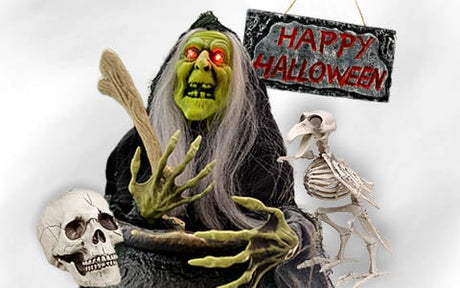 Eine Hexe mit grünem Gesicht und leuchtend roten Augen hält einen Knochen neben einem menschlichen Schädel, einem Vogelskelett und einem „Happy Halloween“-Schild vor einem grauen Hintergrund.