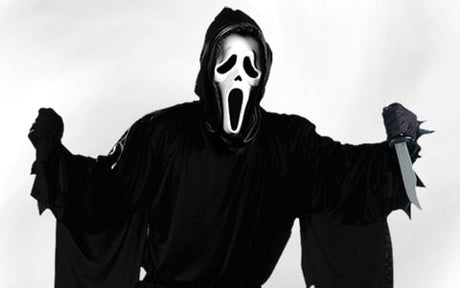 Eine Person in einem schwarzen Kapuzenmantel, die eine weiße Ghostface-Maske trägt und in einer Hand ein Messer hält.