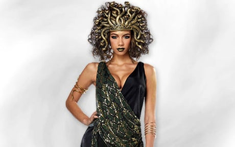 Eine Person in einem von der griechischen Mythologie inspirierten Medusa-Kostüm mit einem Schlangenkopfschmuck, einem schwarz-grünen Kleid und goldenen Accessoires, die vor einem hellen, unscharfen Hintergrund posiert.