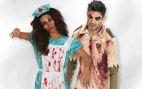 Zwei Personen in Zombie-Kostümen, eine als Krankenschwester und eine als Sheriff, mit Blutflecken und Make-up, um wie Untote auszusehen.