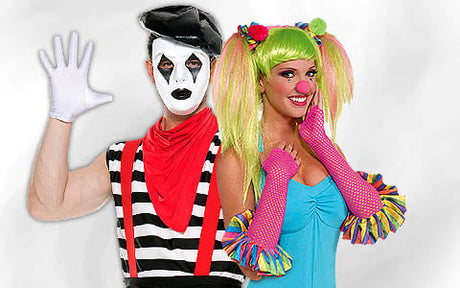 Ein als Pantomime verkleideter Mann und eine als bunter Clown verkleidete Frau posieren gemeinsam vor einem neutralen Hintergrund.