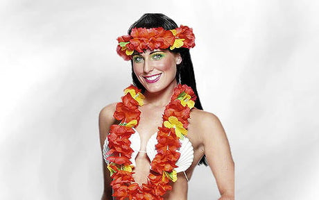 Eine Frau in einem weißen Bikini-Oberteil, die eine rot-gelbe Blumenkette und ein dazu passendes Blumenstirnband trägt, steht vor einem schlichten, hellen Hintergrund.