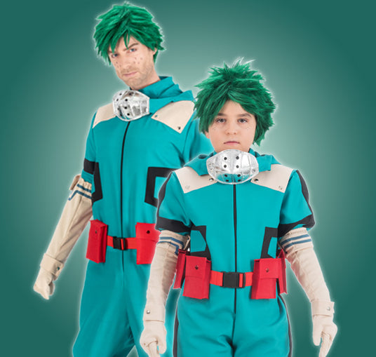 Ein Erwachsener und ein Kind, die passende blaugrüne Overalls, grüne Perücken und rote Werkzeuggürtel tragen und als Figuren aus einem Anime verkleidet sind, stehen vor einem grünen Hintergrund mit Farbverlauf.