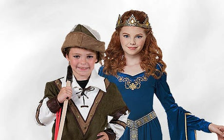 Ein kleiner Junge in einem Robin-Hood-Kostüm steht neben einem Mädchen in einem blauen mittelalterlichen Prinzessinnenkleid und mit einer goldenen Krone; beide blicken nach vorne.