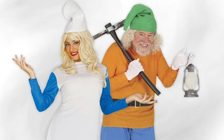 Zwei Erwachsene in von den Schlümpfen inspirierten Kostümen; einer trägt einen weißen Hut und ein weißes Kleid und hat langes blondes Haar, während der andere einen grünen Hut und ein orangefarbenes Hemd trägt, eine Spitzhacke in der Hand hält und eine Laterne bei sich trägt.