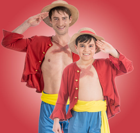 Ein Erwachsener und ein Kind in passenden Piratenkostümen mit Strohhüten, roten Hemden, blauen Shorts und gelben Schärpen, die beide vor einem roten Hintergrund salutieren.