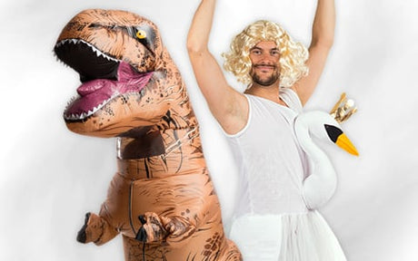 Eine Person in einem T-Rex-Kostüm steht neben einer Person, die ein weißes Kleid, eine blonde Perücke und ein Schwan-Accessoire trägt.