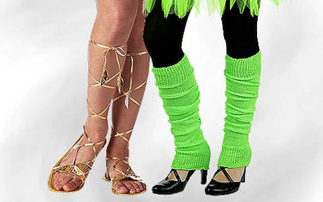Zwei Menschen stehen nebeneinander; der eine trägt goldene Sandalen mit Schnürriemen, die andere trägt grüne Stulpen über schwarzen Strumpfhosen und schwarze Pumps.