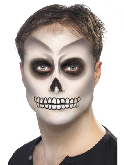 Eine Person mit Skelett-Gesichtsbemalung, die dunkle Augenhöhlen, eine schwarze Nase und über die Lippen gemalte Zähne aufweist und ein schwarzes T-Shirt trägt.
