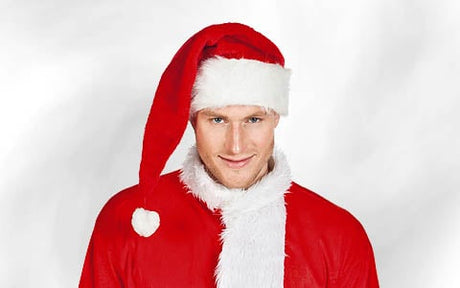 Eine Person, die eine rote Weihnachtsmannmütze und ein rotes Outfit mit weißem Besatz trägt und vor einem schlichten weißen Hintergrund steht.