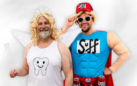 Zwei Männer in lustigen Kostümen: Der eine ist als Zahnfee verkleidet, mit einem Tanktop mit Zahnmotiv und einem Zauberstab, der andere als Superheld mit Umhang, Sonnenbrille und Getränkedosen um die Hüfte.