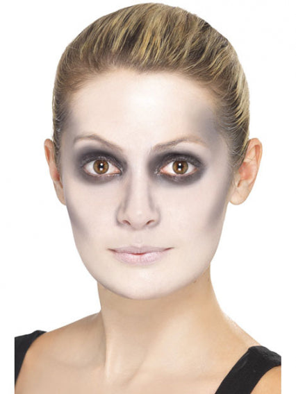 Eine Person mit nach hinten geglätteten Haaren, auffälligem schwarzem Lidschatten um die Augen, blassem Make-up im Gesicht und neutralen Lippen, die geradeaus blickt.
