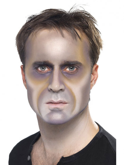 Ein Mann mit kurzen braunen Haaren blickt in die Kamera; sein Gesicht ist mit grauer, weißer und violetter Schminke bemalt, was einen dramatischen, überirdischen Effekt erzeugt.
