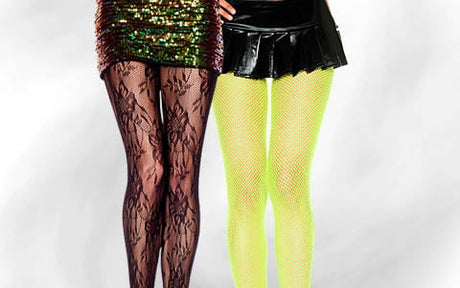 Zwei Personen stehen nebeneinander, die eine trägt einen Paillettenrock und Spitzenstrumpfhosen, die andere einen schwarzen Minirock und neonfarbene Netzstrumpfhosen; beide blicken vorwärts vor einem weißen Hintergrund.